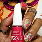 Unhas para o Carnaval: tendências, dicas para durar mais e os esmaltes que realmente funcionam Unhas para o Carnaval: nail art com bolinhas coloridas no dedo médio e no dedo anelar.