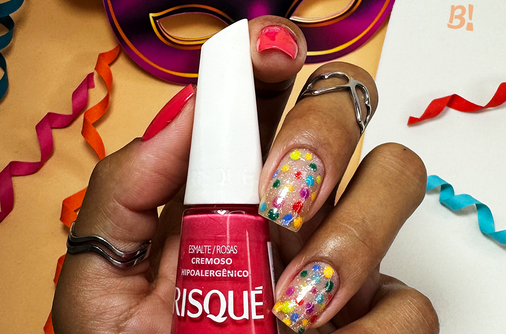 Unhas para o Carnaval: nail art com bolinhas coloridas no dedo médio e no dedo anelar.